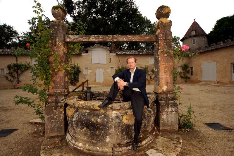 Pierre Lurton at Château d'Yquem. He is sitting on the well in the courtyard, The mottled stone reflecting the variation of golden colours and the complexity of the wine through the vintages. The roses make reference to the floral notes and femininity of the wine.